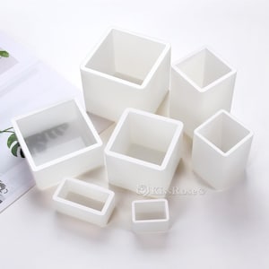 Peut inclure: Ensemble de six moules carrés en silicone blanc de différentes tailles. Les moules sont parfaits pour faire de petits gâteaux, des savons ou d'autres objets artisanaux.