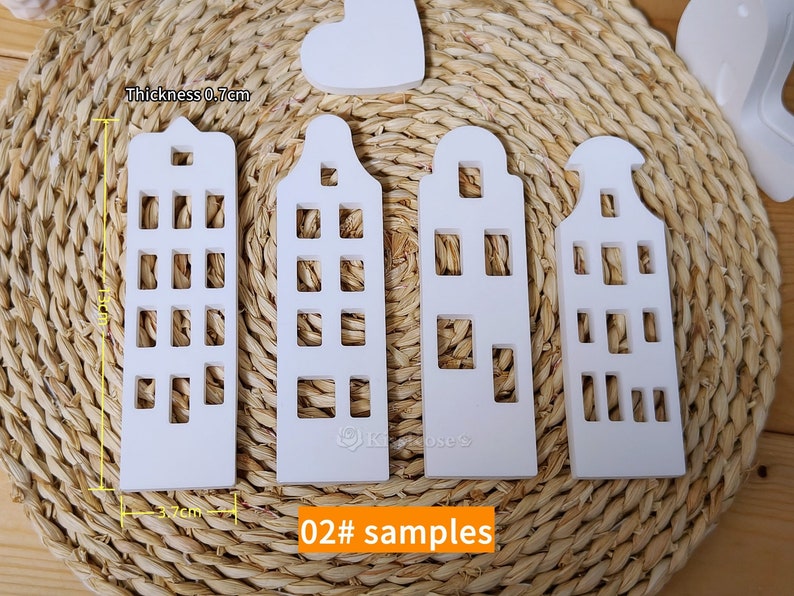 May include: Four white wooden houses with cut-out windows, each measuring 3.7 inches tall and 0.7 inches thick. The houses are arranged in a row on a woven straw mat. The text "02# samples" is printed below the houses.
