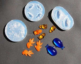 May include: Two silicone molds for making resin crafts. One mold is round and features four goldfish designs. The other mold is oval and features two fish designs. There are also several small resin goldfish and two blue resin fish.