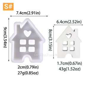 May include: Two white silicone molds shaped like houses with a heart cutout. The larger mold is 7.4 inches wide and 9 inches tall, weighing 0.85 ounces. The smaller mold is 6.4 inches wide and 8 inches tall, weighing 1.52 ounces.