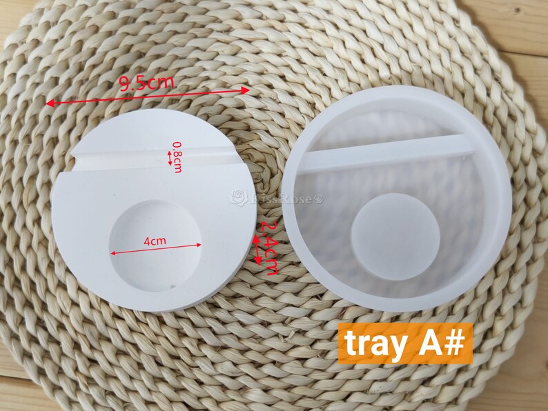 May include: Two white silicone molds for resin crafts. The mold on the left is 9.5 cm wide and has a 4 cm circle and a 0.8 cm slot. The mold on the right is a tray with a 4 cm circle and a divider. The text "tray A#" is visible in the image.