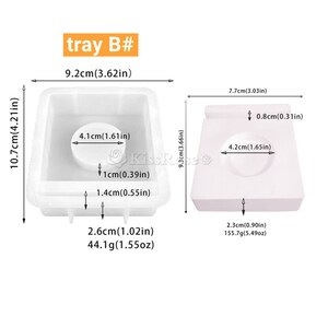 May include: Two white silicone molds for making soap or candles. The larger mold is 9.2 inches wide, 10.7 inches tall, and 2.6 inches deep. The smaller mold is 7.7 inches wide, 9.3 inches tall, and 2.3 inches deep. Both molds have a circular indentation in the center.