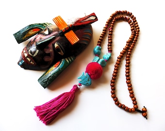 Long boho necklace made of wooden beads and turquoise stones. Pendant FISH stone ornament, pompon and tassel of wool. Completion of macramé.