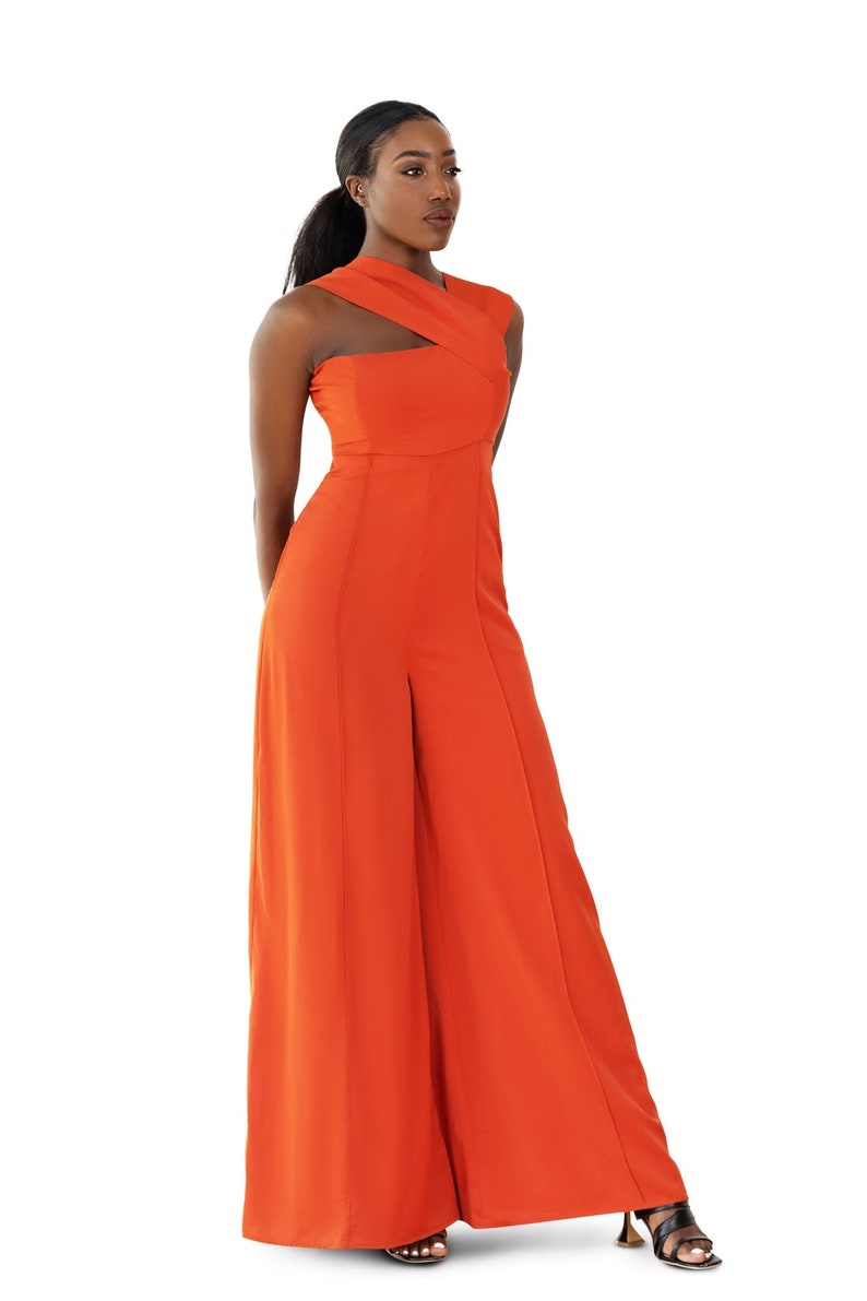 Model wearing Onika Orange Jumpsuit with asymmetrical neckline