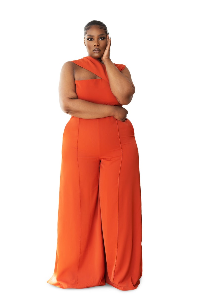 Model wearing Onika Orange Jumpsuit with asymmetrical neckline, wide leg pants