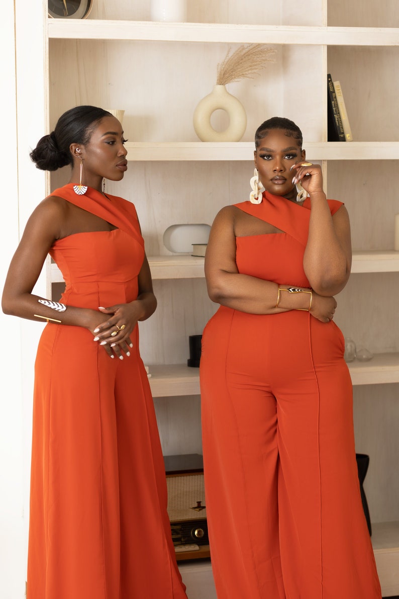 Models wearing Onika Orange Jumpsuit with asymmetrical neckline