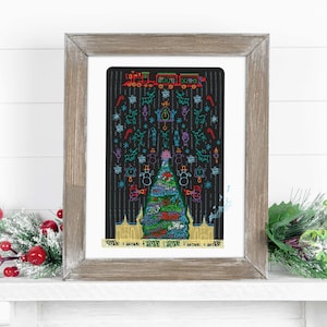 May include: A framed Christmas-themed print with a black background. The artwork features a colorful Christmas tree, a train, snowflakes, and other festive elements. The frame is a light brown color, and the print is displayed on a white surface.