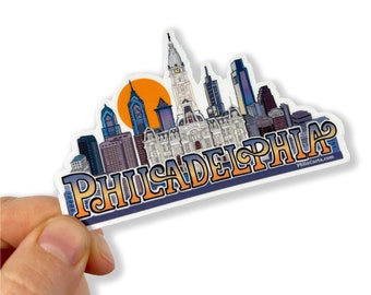 May include: A sticker featuring a colorful illustration of the Philadelphia skyline with the word "Philadelphia" in a retro font. The sticker has a white background and a yellow and orange sunset.