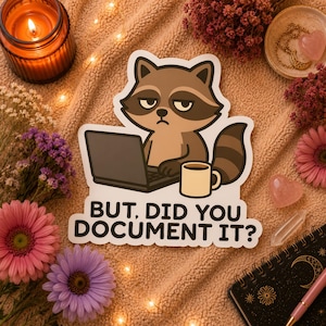May include: A sticker featuring a cartoon raccoon with a laptop and coffee mug. The raccoon has a grumpy expression. The text on the sticker reads, "BUT, DID YOU DOCUMENT IT?" The sticker is surrounded by flowers, a candle, and a notebook.
