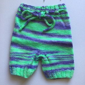 Puede incluir: Pantalones de bebé de punto a rayas verdes y moradas con cordón de ajuste en la cintura.
