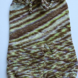 May include: Striped knit baby pants with a brown, green, and purple color scheme. The pants have a drawstring waist and a gathered leg.