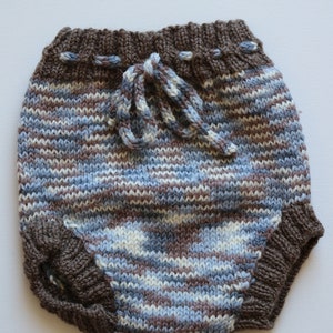 Puede incluir: Braguitas de bebé de punto a rayas marrones y azules con un cordón de ajuste marrón.
