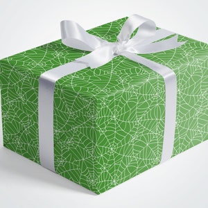 May include: A green gift box with a white spiderweb pattern and a white satin ribbon.