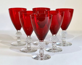 May include: Set of six red wine glasses with clear, textured stems and bases. Each glass has a round, clear, textured knob at the base of the stem.