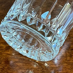 Puede incluir: Un vaso de vidrio transparente con un dise&ntilde;o de vidrio cortado. El vaso tiene una base gruesa y una boca ancha.