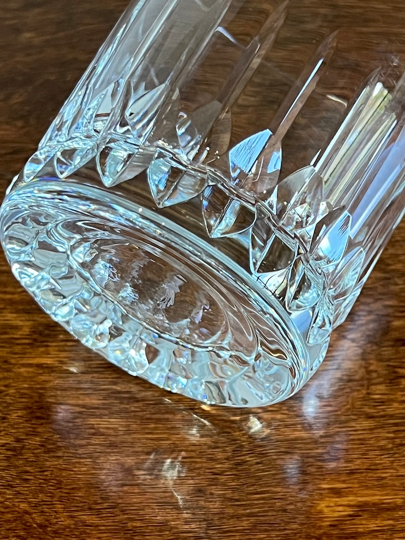 Puede incluir: Un vaso de vidrio transparente con un dise&ntilde;o de vidrio cortado. El vaso tiene una base gruesa y una boca ancha.