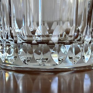 Puede incluir: Primer plano de la parte inferior de un vaso transparente con un dise&ntilde;o de vidrio cortado. El vaso tiene un patr&oacute;n de diamante alrededor de la base.