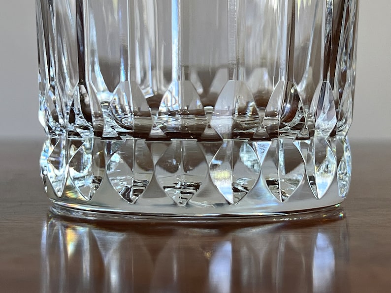 Puede incluir: Primer plano de la parte inferior de un vaso transparente con un dise&ntilde;o de vidrio cortado. El vaso tiene un patr&oacute;n de diamante alrededor de la base.