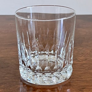 Puede incluir: Un vaso de vidrio transparente con un dise&ntilde;o de vidrio cortado. El vaso tiene una base redonda y lados rectos.