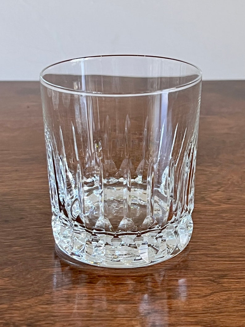 Puede incluir: Un vaso de vidrio transparente con un dise&ntilde;o de vidrio cortado. El vaso tiene una base redonda y lados rectos.