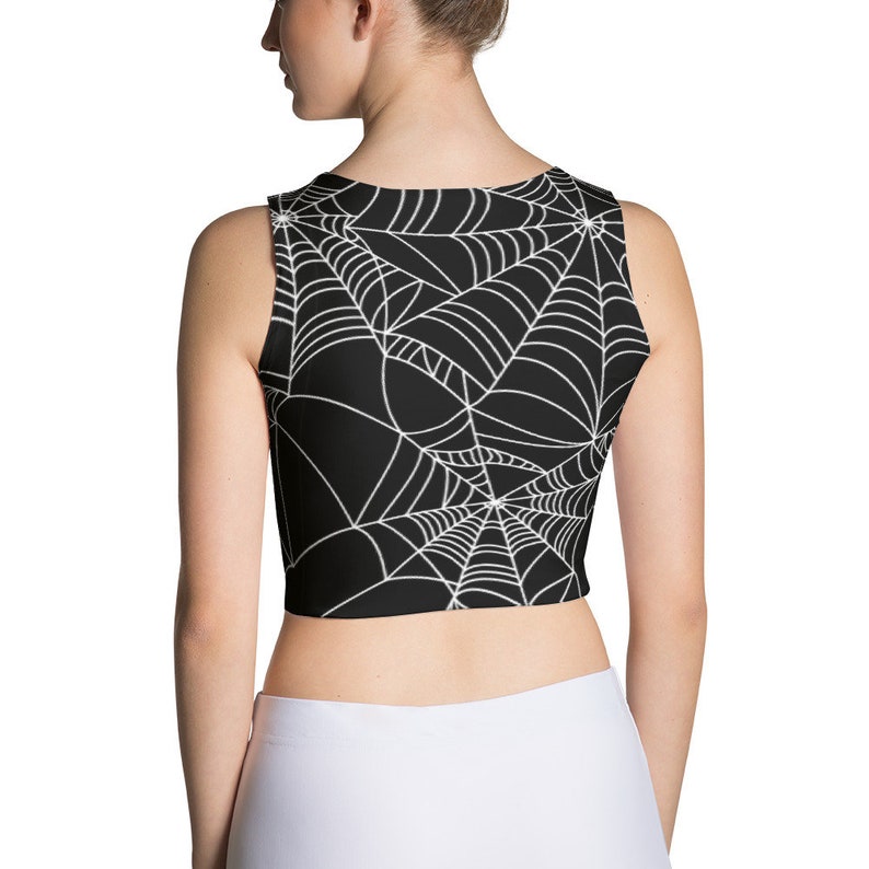 May include: Black sleeveless crop top with a white spiderweb pattern.