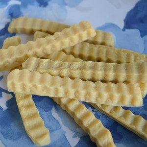 K&ouml;nnte beinhalten: Nahaufnahme eines Tellers mit hellbraunen, gewellten, knusprigen Pommes Frites.