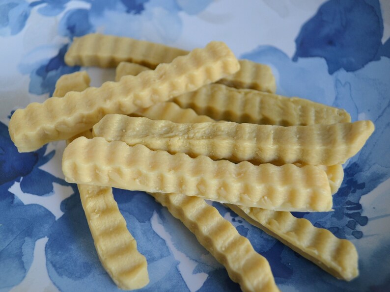 K&ouml;nnte beinhalten: Nahaufnahme eines Tellers mit hellbraunen, gewellten, knusprigen Pommes Frites.