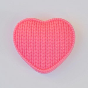 May include: A pink heart-shaped soap with a knitted texture.