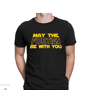 Op de afbeelding: Zwart T-shirt met gele tekst die "Moge de veertigers met je zijn" zegt.