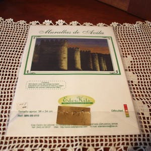 May include: A craft kit featuring an image of the Walls of Avila. The kit includes a picture of the walls with a green border, the text "Murallas de Avila", and the dimensions of the kit, approximately 15 x 9.5 inches.