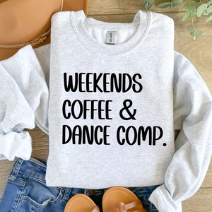 May include: A gray sweatshirt with the text "Weekends Coffee & Dance Comp." printed in black.