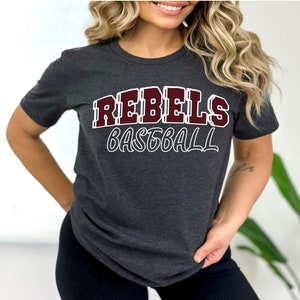 May include: A dark gray t-shirt with the words "REBELs BASEBALL" printed in maroon letters with a white outline.