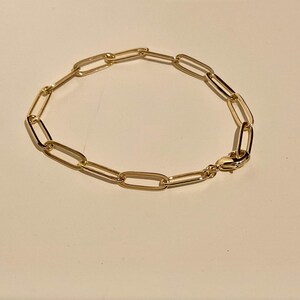 May include: A gold chain bracelet with a simple, linked design.