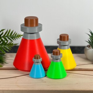 May include: A set of four conical potion bottles in varying sizes, featuring bright red, yellow, green, and blue bodies. Each bottle is topped with a grey collar and a brown cylindrical stopper, creating a uniform design across all four pieces.