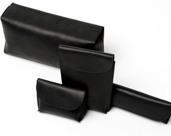 Puede incluir: Cuatro bolsas de cuero negro de diferentes tamaños. Las bolsas están hechas de cuero suave y flexible y tienen un diseño simple y elegante.
