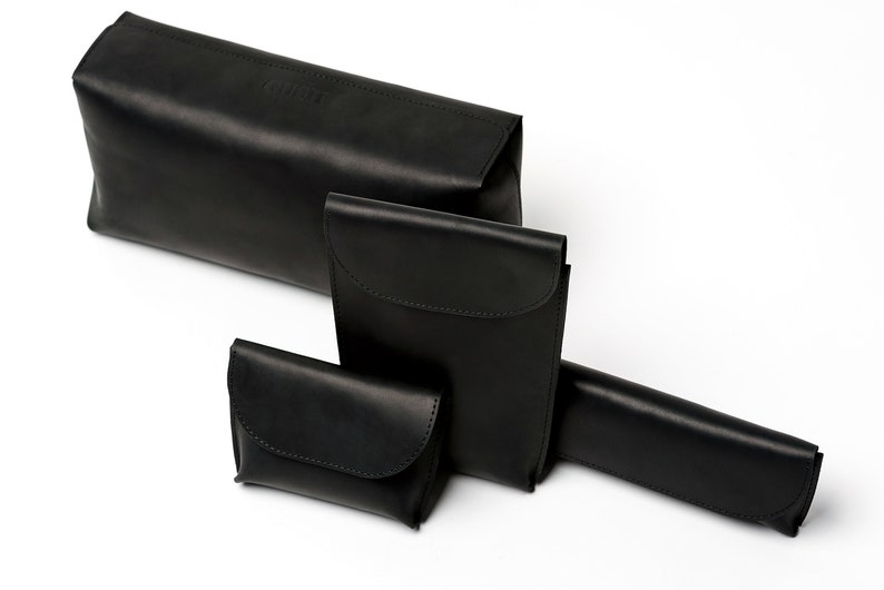 Puede incluir: Cuatro bolsas de cuero negro de diferentes tama&ntilde;os. Las bolsas est&aacute;n hechas de cuero suave y flexible y tienen un dise&ntilde;o simple y elegante.