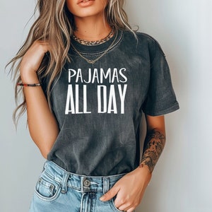 a woman wearing a t - shirt that says pajamas all day