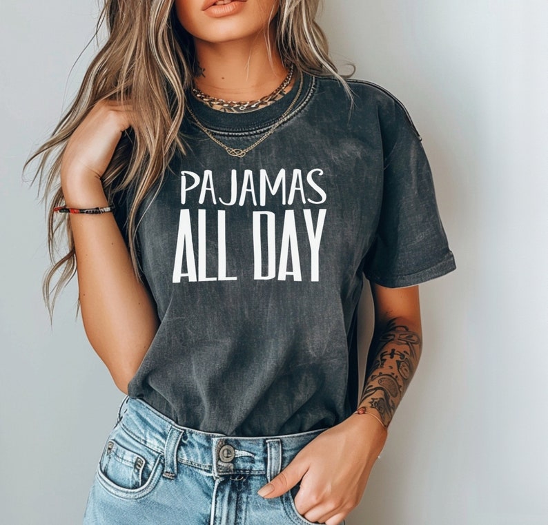 a woman wearing a t - shirt that says pajamas all day