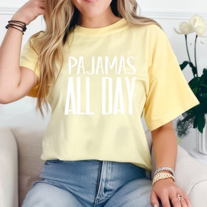 a woman sitting on a couch wearing a yellow shirt