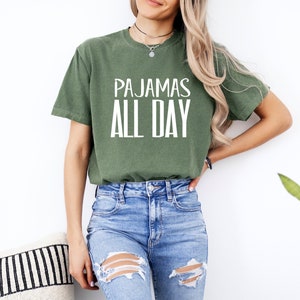 a woman wearing a green shirt that says pajamas all day