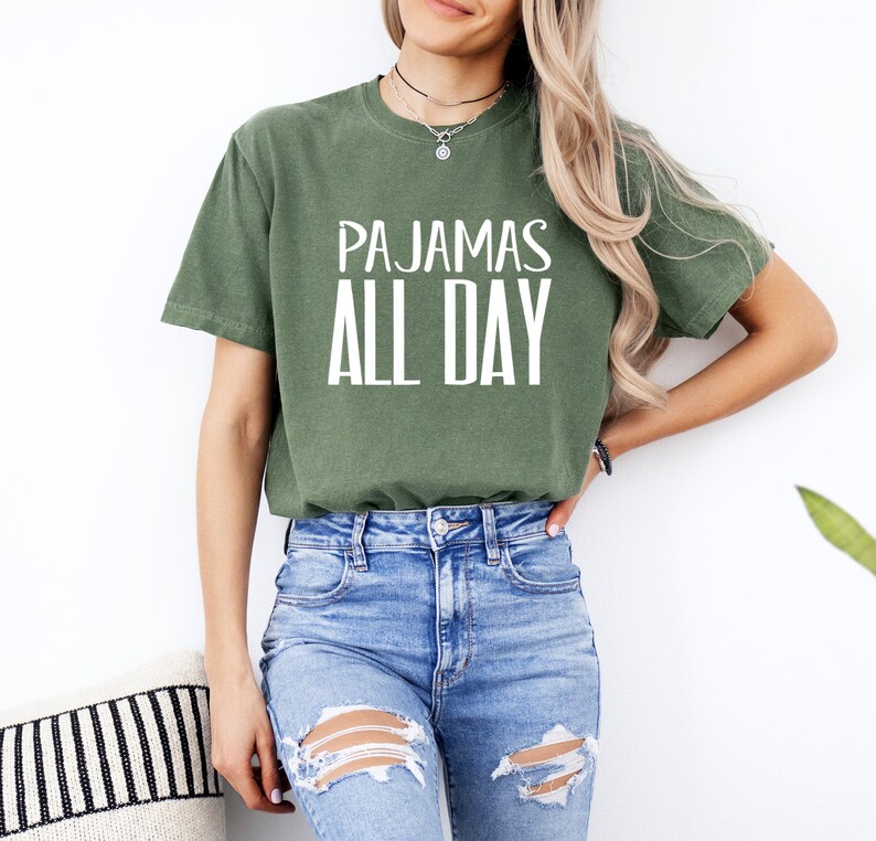 a woman wearing a green shirt that says pajamas all day