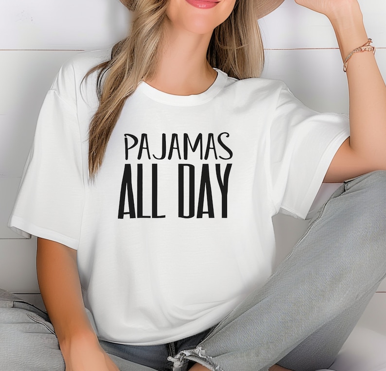 a woman wearing a white t - shirt that says pajamas all day