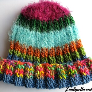Peut inclure: Un chapeau crocheté coloré avec des rayures roses, vertes, bleues, oranges et un fond multicolore.