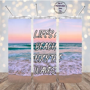 May include: A stainless steel tumbler with a sunset beach scene and the text "Life's a beach, enjoy the waves".