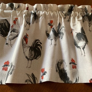 May include: A white valance with a repeating pattern of black and gray roosters with red combs. The valance has a ruffled edge.