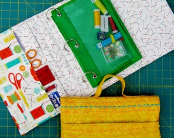 May include: A white and red fabric sewing kit with a green zippered pouch containing sewing supplies. The kit has a yellow fabric flap with a floral pattern and is closed with a snap.