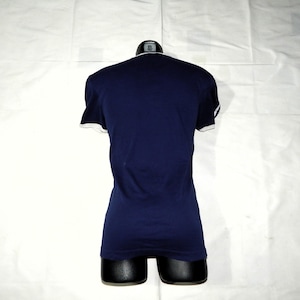 May include: A navy blue t-shirt with white trim around the neckline and sleeves.