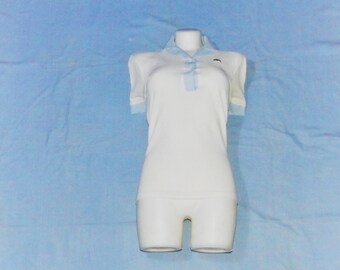 May include: A white collared shirt with a light blue trim on the collar and cuffs. The shirt is on a mannequin and is displayed on a light blue background.