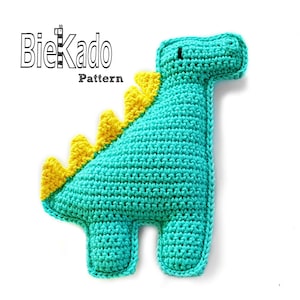 Puede incluir: Un juguete de dinosaurio de crochet con un cuerpo turquesa, espinas amarillas y ojos negros. El juguete está hecho con un hilo suave y texturizado y es perfecto para acurrucarse.