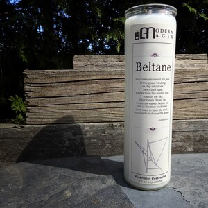 May include: White candle with a black and white graphic design and the text "Beltane" and "Watermint Cementine 10 oz soy candle".